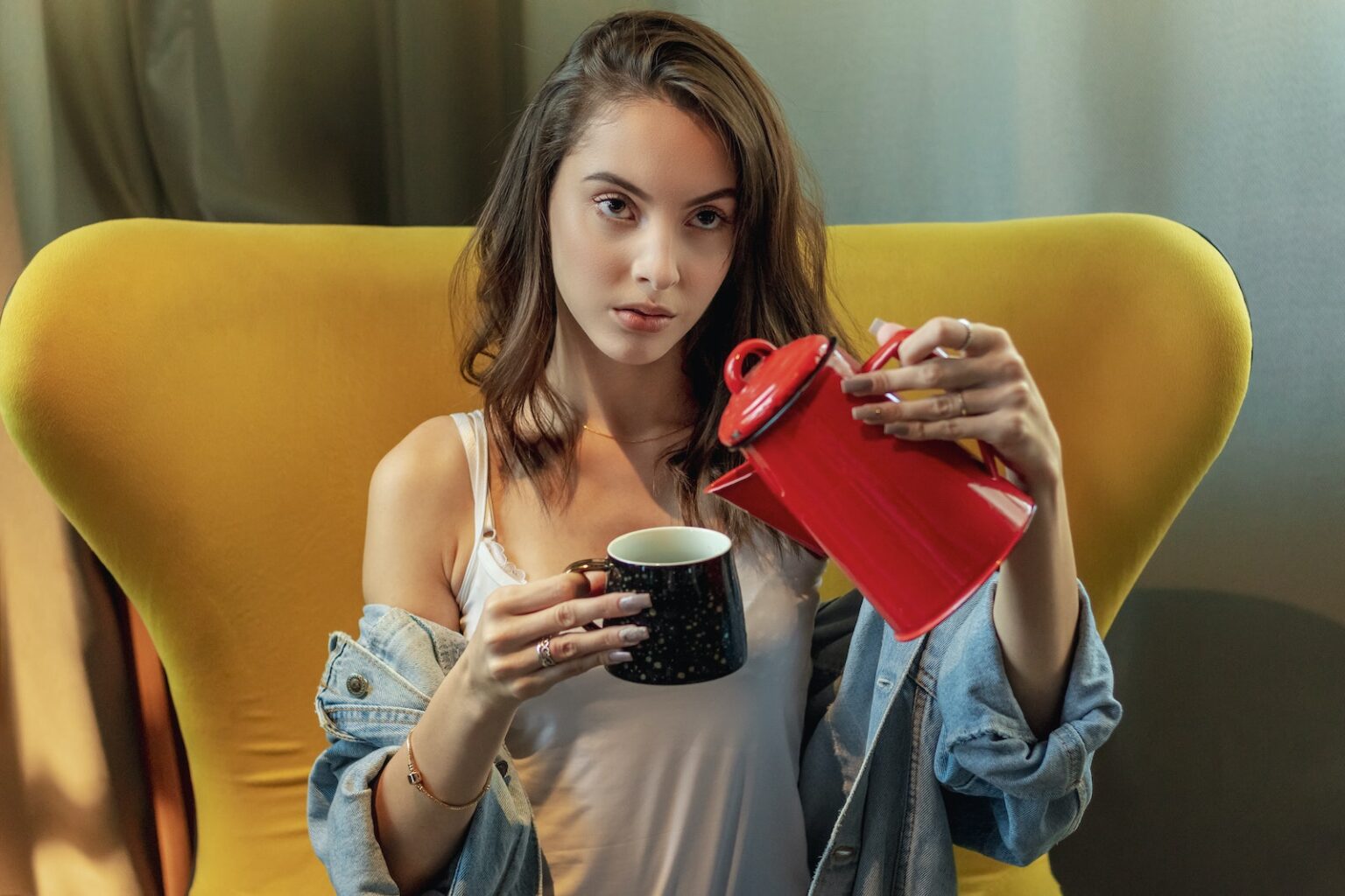 Photo of a Woman Pouring Pitcher on Cup