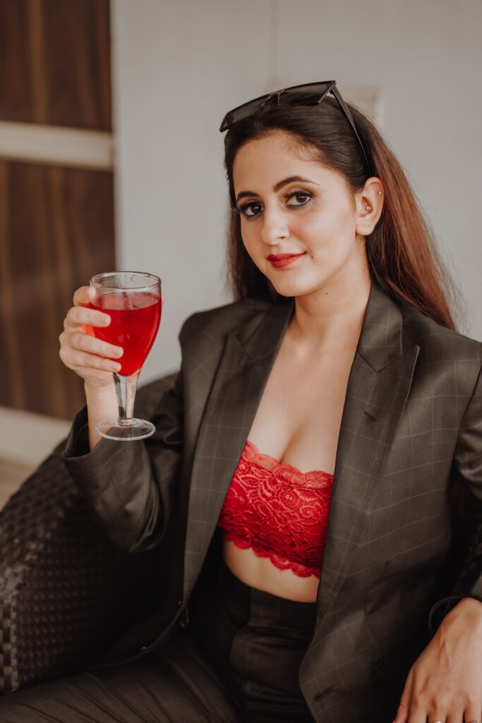 woman in black blazer holding red wine glass